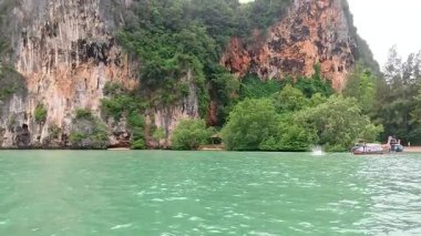 Railay Körfezi Sahili 'nde kayıklar ve yemyeşil alanlar.