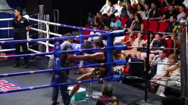 Boksörler ringde hazırlanır, seyirciler yakından izler.