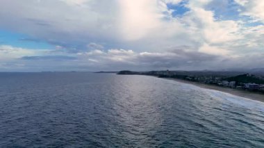 Renkli bir günbatımı gökyüzünün altında okyanus dalgaları