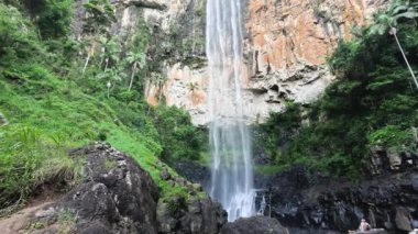 Uzun şelale kayalıklardan aşağı dökülüyor.