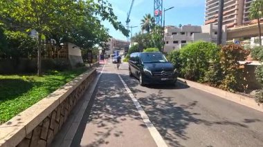 Bisikletçiler Monte Carlo manzarasında gezerler.