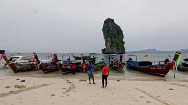 Tekneler ve insanlar kumlu bir sahilde