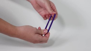 İki el mor bir saç teli çekiyor.