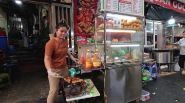 Tedarikçi sokak tezgahında yemek hazırlıyor.