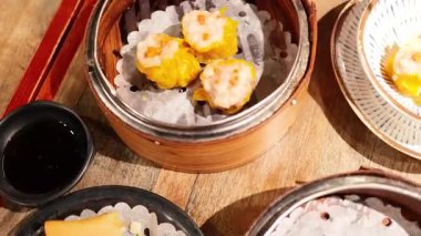 Ahşap bir masada çeşitli Dim Sum tabakları