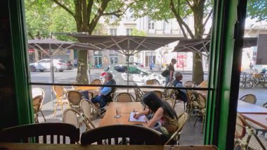 İnsanlar kafede güneşli bir günün tadını çıkarıyorlar.