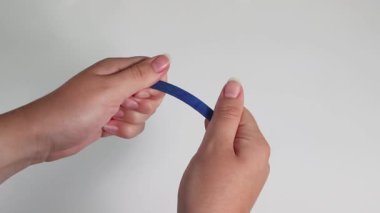 Eller mavi bir kalemi iki parçaya böler.