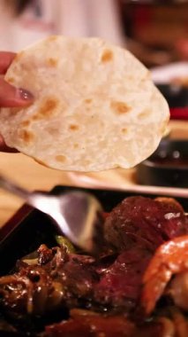 Sıcak, davetkar bir restoran ortamında tlayudaları ızgara et ve karidesle bir araya getirmek.