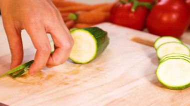 Yakında domates ve havuçla salatalık doğrayan eller.