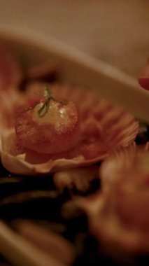 Izgara deniz tarakları, yumuşak ışıklandırmalı sıcak ve samimi bir ortamda aşçılık sanatını ön plana çıkaran kabuklarda özenle düzenlenmiştir.