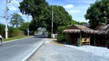 Bir araba kırsal bir barakanın yanından geçiyor.