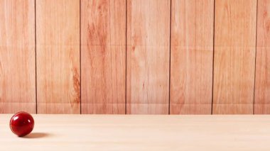Bir kriket topu ahşap bir yüzey boyunca yuvarlanır.