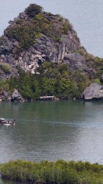 Bereketli adalarla çevrili sakin sularda süzülen bir tekne, huzurlu ve resimsel bir manzara yakalıyor.