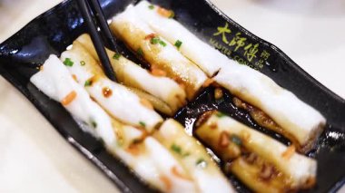 Çubuklar soslu erişteli pirinç rulosu kaldırıyor.