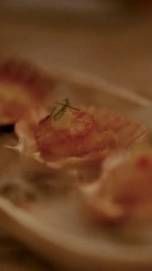 Kabukların üzerinde ızgara deniz tarağı, sıcak, çevresel aydınlatma altında, mutfak sunumu ve güzel yemek atmosferi.