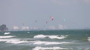 Uçurtma sörfçüleri dalgalı okyanus dalgalarında süzülür