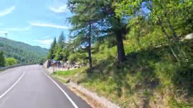 Dönek bir dağ yolunda motosikletler ve arabalar