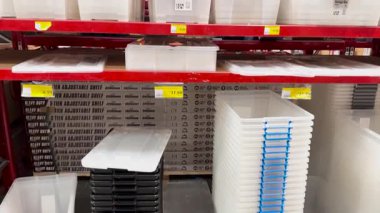 Raflar çeşitli plastik kutularla dolu.