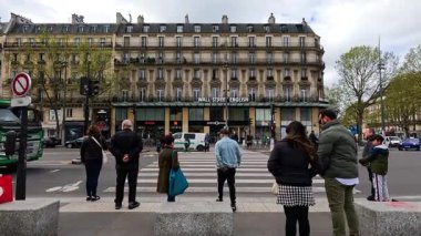 İnsanlar Paris kavşağında bekleyip geçiyorlar.