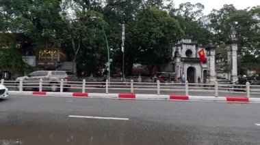 Islak bir caddeden geçen araçlar ve motorsikletler