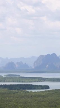 Phang Nga Körfezi 'nin panoramik manzarası. Kireçtaşı kayalıkları ve yemyeşil gökyüzü parçalı bulutlu.
