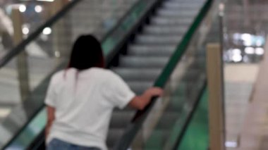 Kapalı bir yürüyen merdivende yükselen kişi
