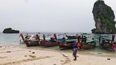 Tekneler ve insanlar kumlu bir sahilde