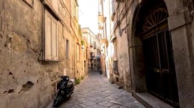 Park etmiş bir motosikleti olan dar bir sokak.