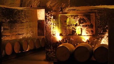 Yeraltı mahzeninde fıçılar ve aydınlatılmış sanat eserleri