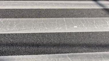 Zebra geçidinde yürüyen kişinin gölgesi