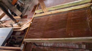 Tahta bıçkıhane makineleri iş başında, geleneksel teknikler sergiliyorlar. Doğal ışıklandırma kırsal çevreyi ve mekanik hareketi vurguluyor