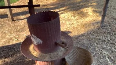 Tayland kırsalında elle pirinç öğütme işlemi