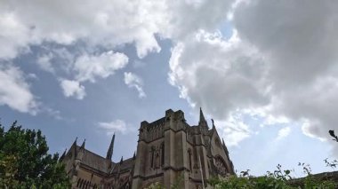 Bulutlu gökyüzünün altında çiçek açan bahçeli bir kale