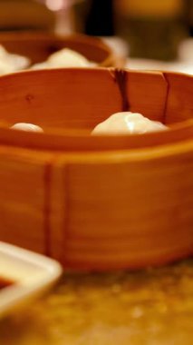 Sos soslu bir masada dumanı tüten Sum sepetleri. Ilık aydınlatma davetkar bir yemek atmosferi yaratır.