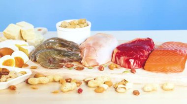 Etler, fındıklar ve süt ürünleri de dahil olmak üzere çeşitli protein zengini gıdaların canlı bir görüntüsü.