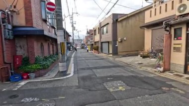 Sakin bir caddede bir araba hareket ediyor.