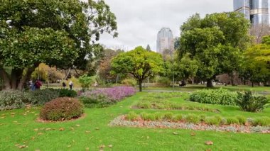 İnsanlar yemyeşil bahçelerde gezmekten zevk alıyorlar.