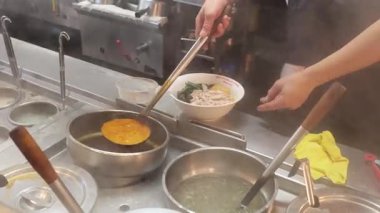 Şef yoğun bir mutfakta erişte hazırlıyor.