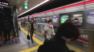 Bir metroya binen ve onu hizalayan yolcular