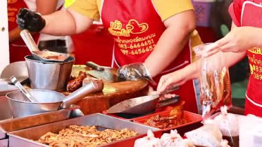 Satıcılar yiyecek hazırlıyor ve paketliyorlar.