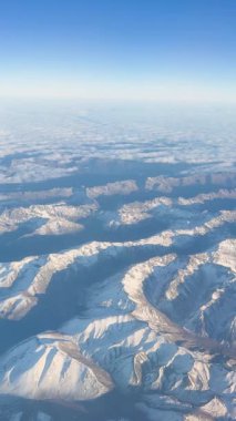 Hava görüntüleri, Auckland, Yeni Zelanda 'daki berrak mavi gökyüzünün altında, sakin ve geniş manzaralı, karla kaplı sıradağları yakalar.