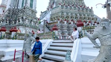 Ziyaretçiler Bangkok, Tayland 'daki Wat Arun tapınağında merdivenlerden çıkıyorlar.