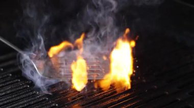 Şiddetli alevler ızgaradaki yiyeceği yutar.
