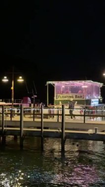 Sudaki yansımalarla aydınlatılan yüzen bir çubuk canlı ve canlı bir atmosfer yaratıyor.