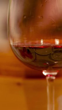 Sıcak ışıklandırması ve rahat bir atmosferi olan rahat bir restoranda kırmızı şarap kadehlerinin yakın çekimi.