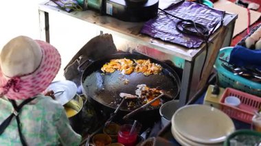 Tedarikçi Bangkok 'ta gevrek midye krepleri hazırlıyor.