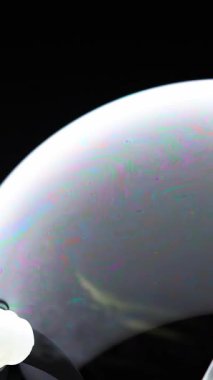 Bir sabun baloncuğunun yüzeyinde canlı renkler kıvrılır, dinamik ışık ve akışkan hareketle yakın plan çekilir.