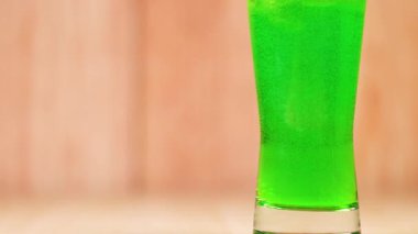 Temiz bardakta parlak yeşil bir içecek.