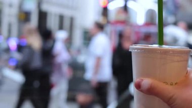 Londra 'nın kalabalık caddesinde kahve fincanı tutarken