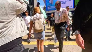 İnsanlar Hong Kong 'da kalabalık bir yaya geçidinde yol alıyorlar.